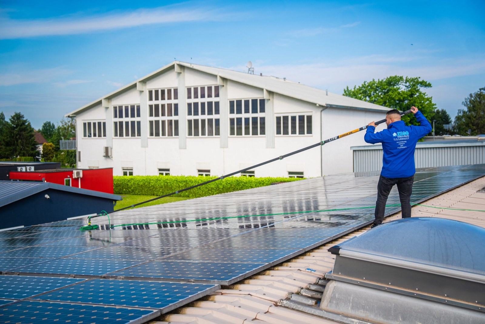 Mitarbeiter von ZEGO reinigt Solarmodule mit Wasserbürste