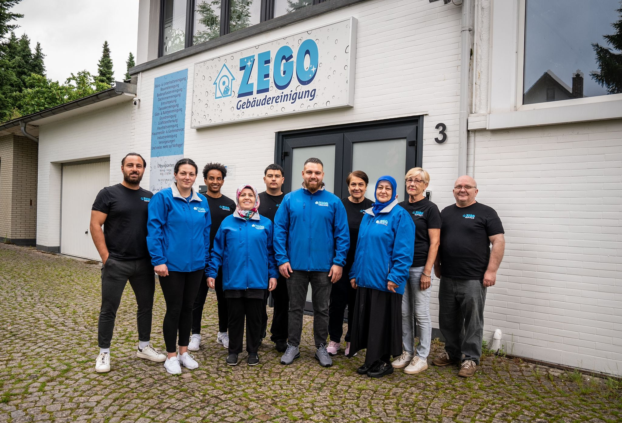 Das Team von ZEGO Gebäudereinigung in Arbeitskleidung vor dem Betrieb in der Grabenstraße in Bühl